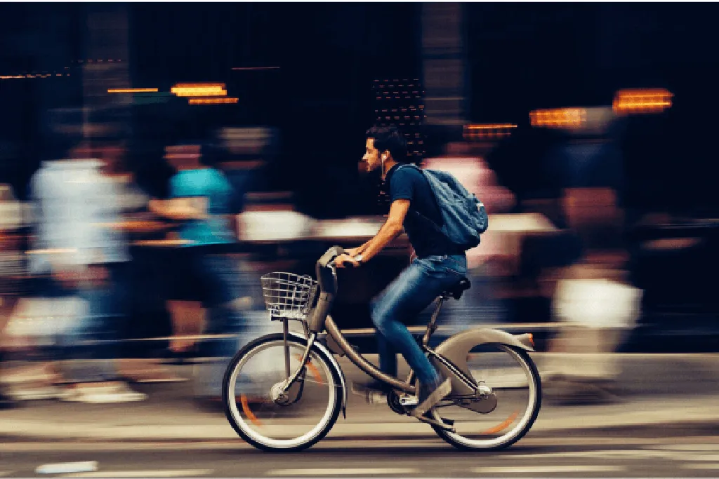 Imagem de ciclista em movimento, simbolizando o conceito de cicloturismo de longa distância em ambiente urbano.